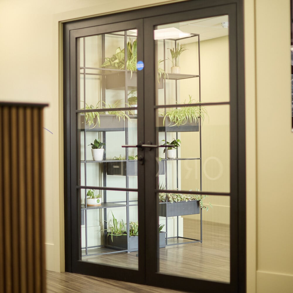 The glass entrance doors with planting inside Oracle House